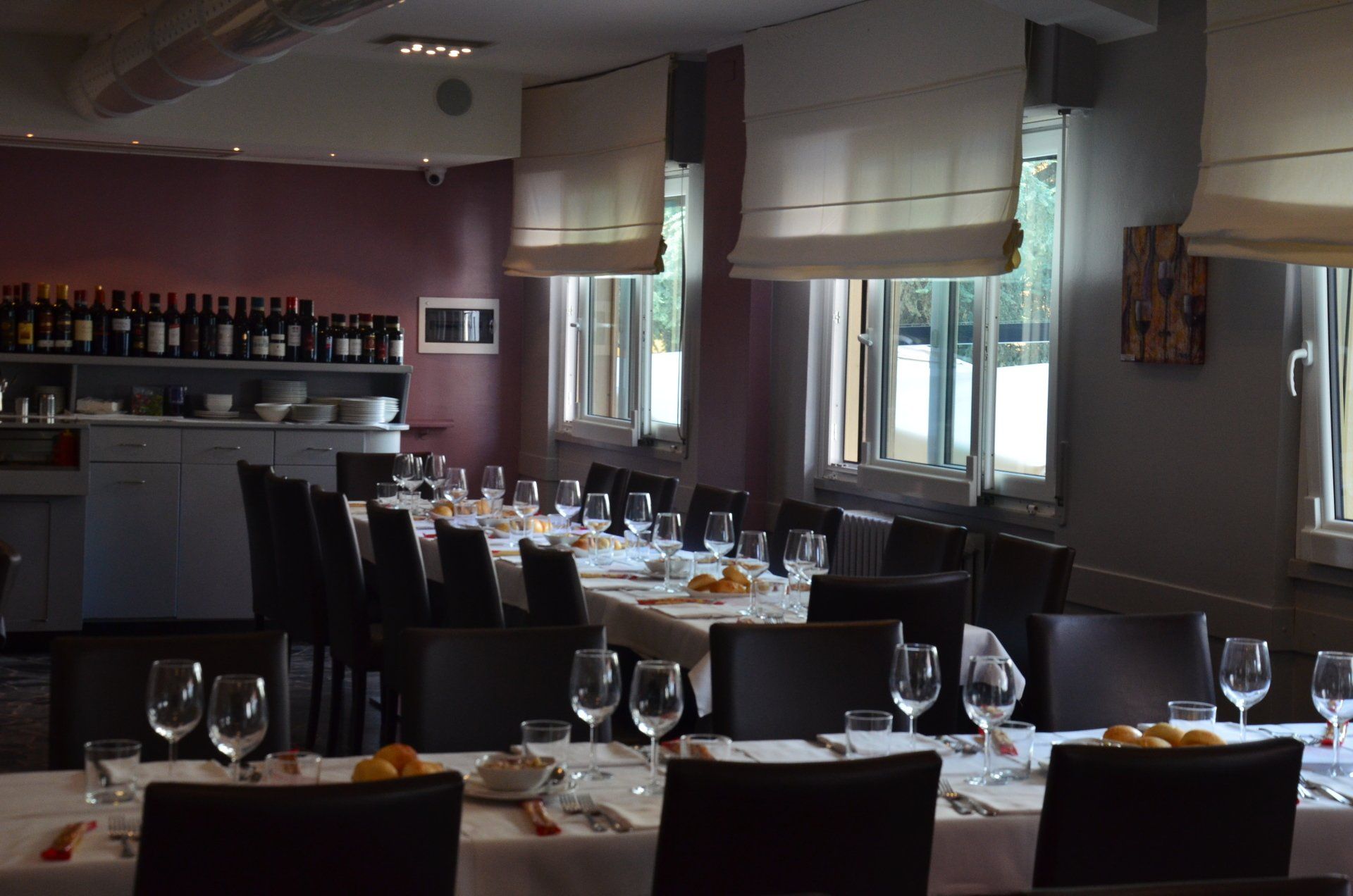 Un ristorante pieno di tavoli, sedie e bicchieri di vino