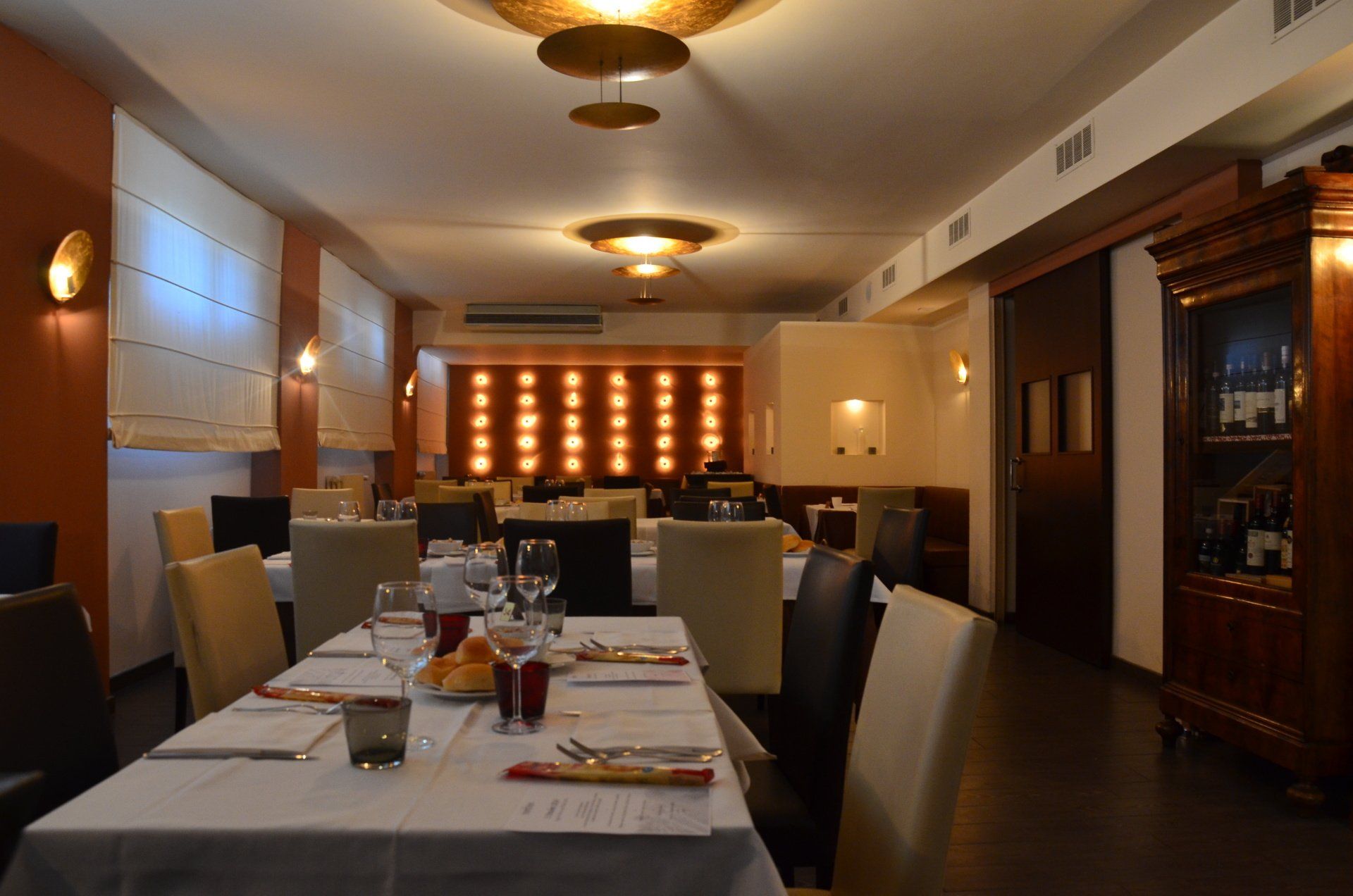 Una sala da pranzo con tavoli e sedie apparecchiati per un pasto