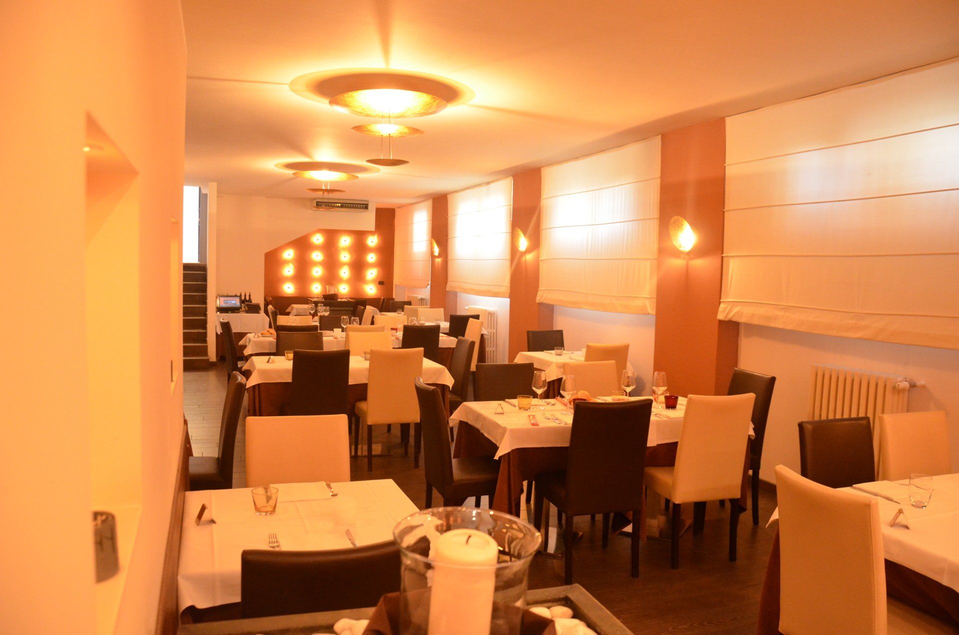 Una grande sala da pranzo con tavoli, sedie e candele