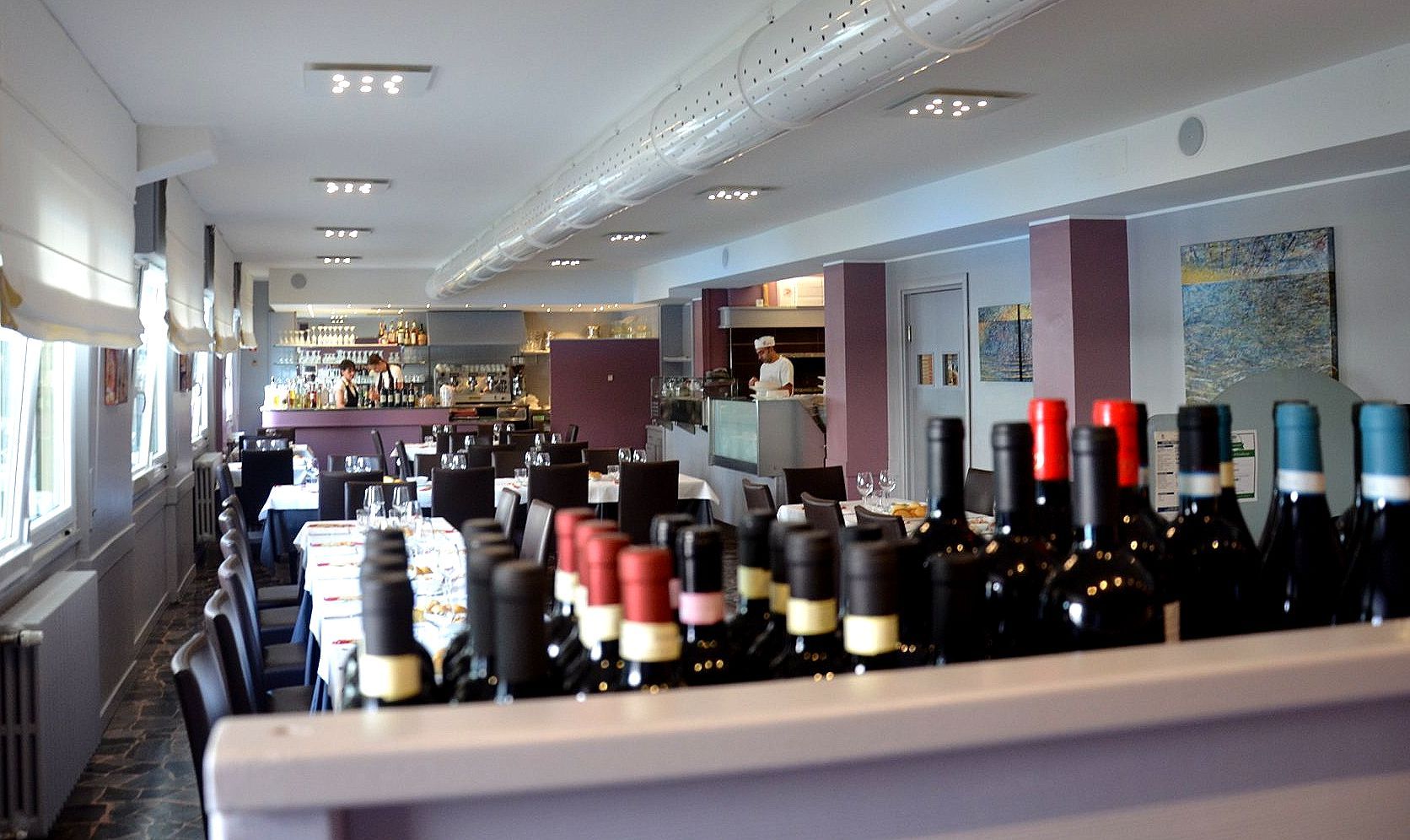 Due bicchieri di vino bianco e un secchiello di champagne su un tavolo di legno.