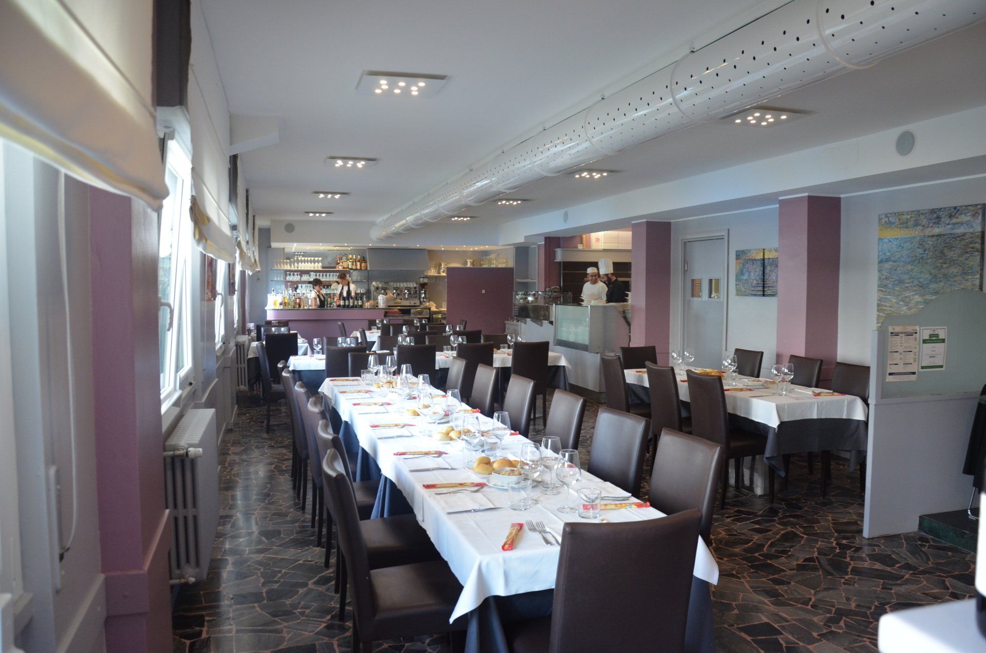 Un ristorante con tavoli e sedie allestiti per un banchetto