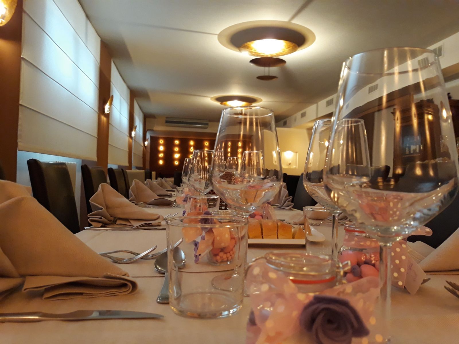 Un lungo tavolo con un sacco di bicchieri da vino sopra