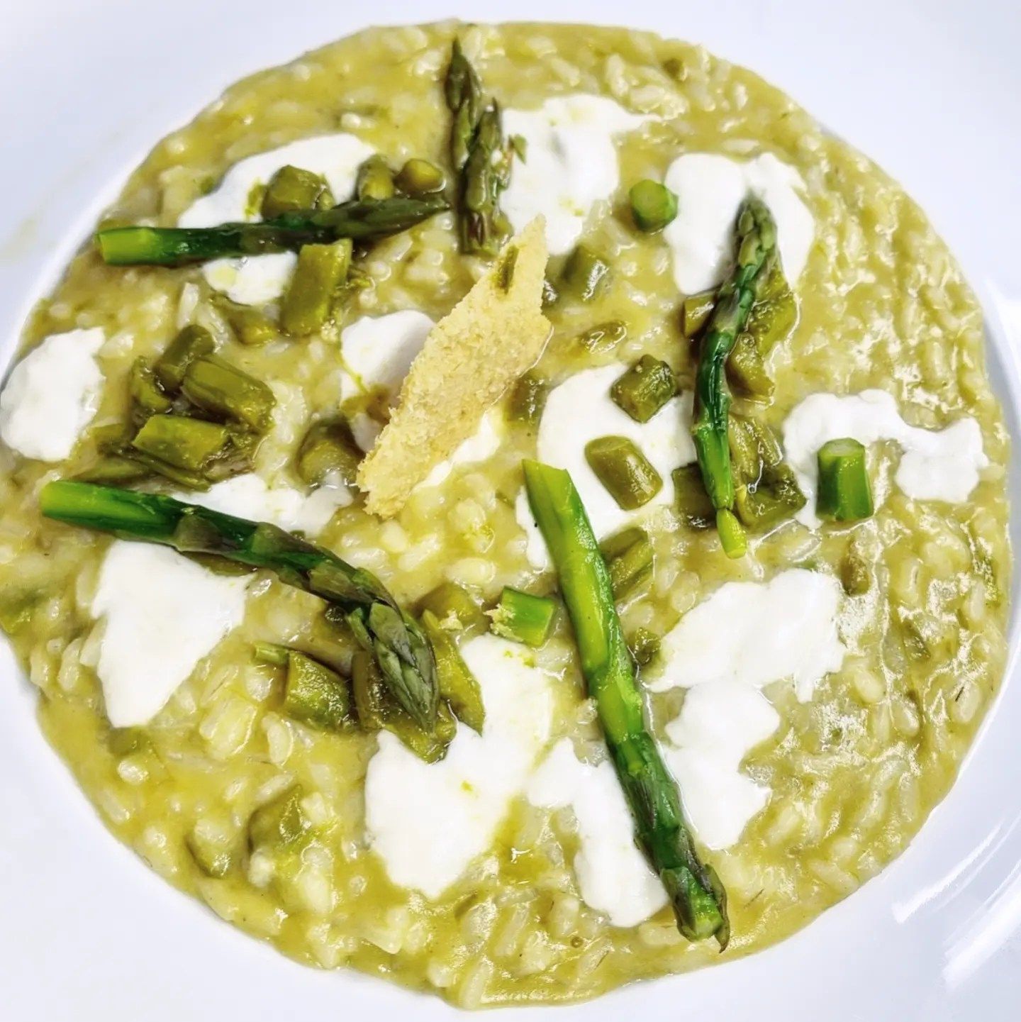 Un primo piano di un piatto di cibo con asparagi e formaggio