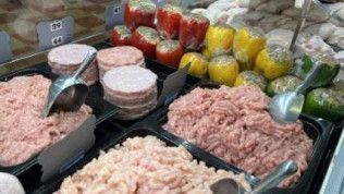 A display case filled with a variety of meats and vegetables.