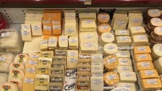 A display case filled with lots of different types of cheese.