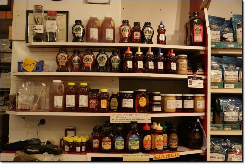 A store shelf filled with jars and bottles of honey