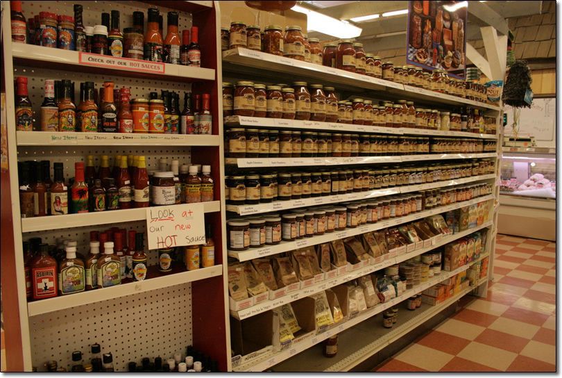 A grocery store aisle filled with jars and bottles of condiments