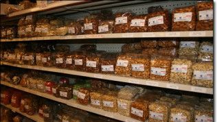 A grocery store shelf filled with bags of nuts.