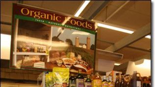 A sign for organic foods hangs from the ceiling of a store