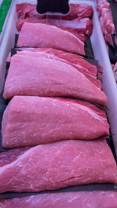 A tray of raw meat is sitting on a table.