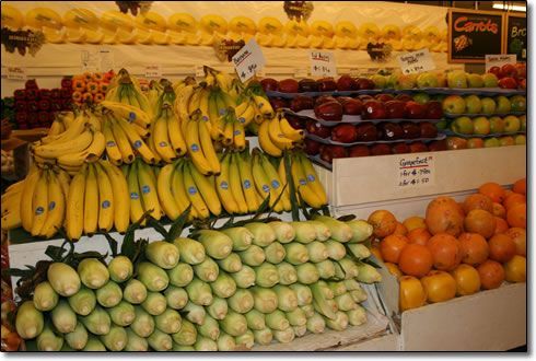A display of fruits and vegetables with a sign that says carrots