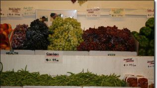 A display of fruits and vegetables including grapes and green beans