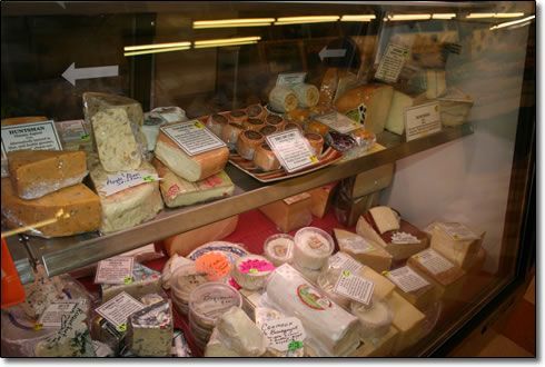 A display case filled with lots of different types of cheese