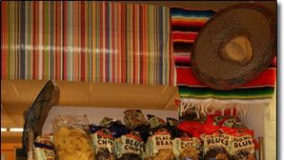 A box of chips and a sombrero on a table.