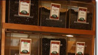 A shelf full of coffee beans with labels on them