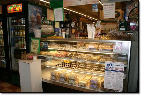 A display case filled with lots of food in a bakery.