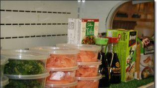 A refrigerator filled with containers of food and sauces.
