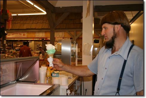 A man is holding an ice cream cone in his hand