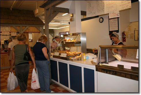 Two women are standing in front of a counter in a bakery