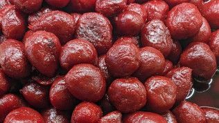 A close up of a pile of red cherries in a bowl.