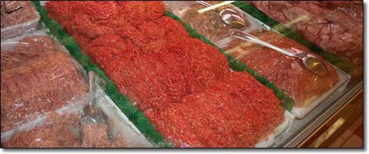 A display case filled with a variety of meats including ground beef