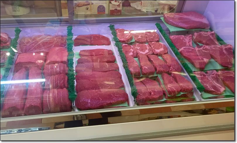 A display case filled with lots of different types of meat.