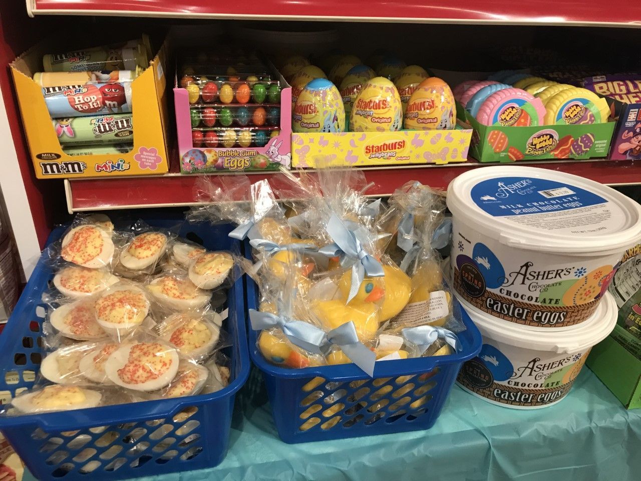 A shelf filled with lots of easter treats and candy.