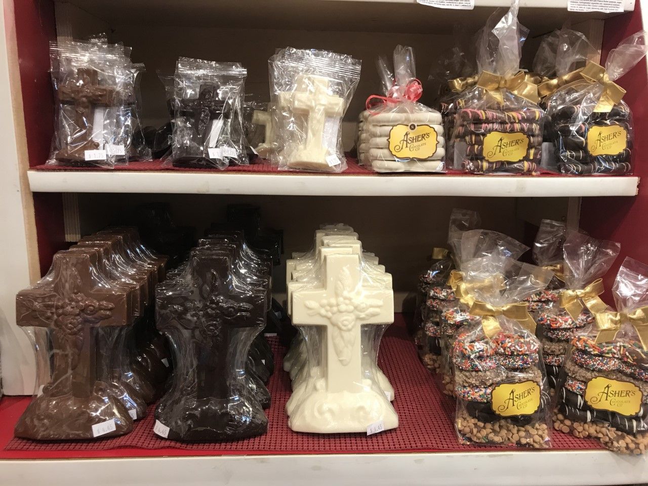 There are many different types of chocolate crosses on the shelves.