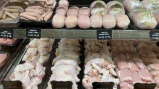 A display case filled with a variety of chicken meats and sausages.