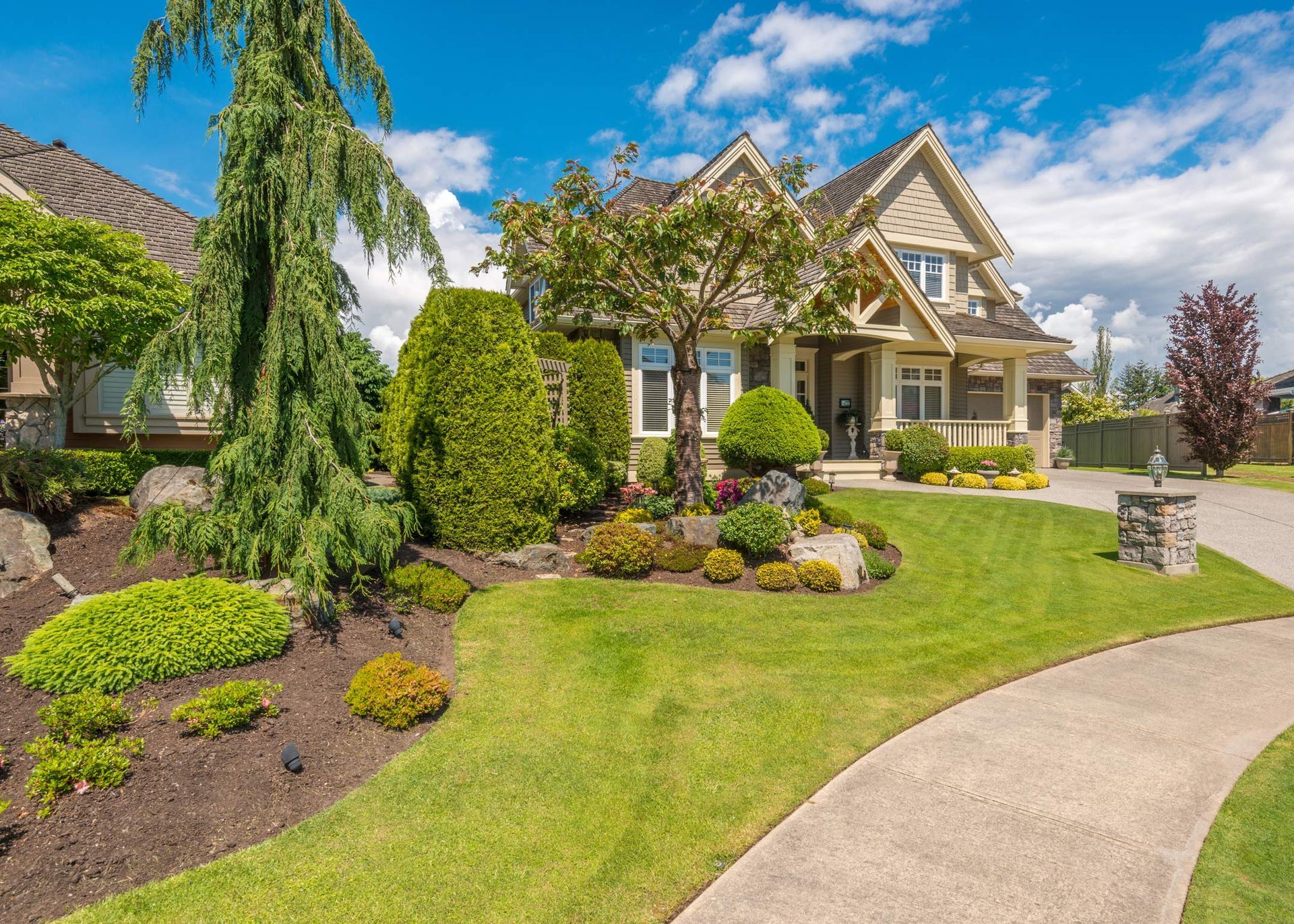 Well-landscaped house with a curved walkway and a lush green lawn.