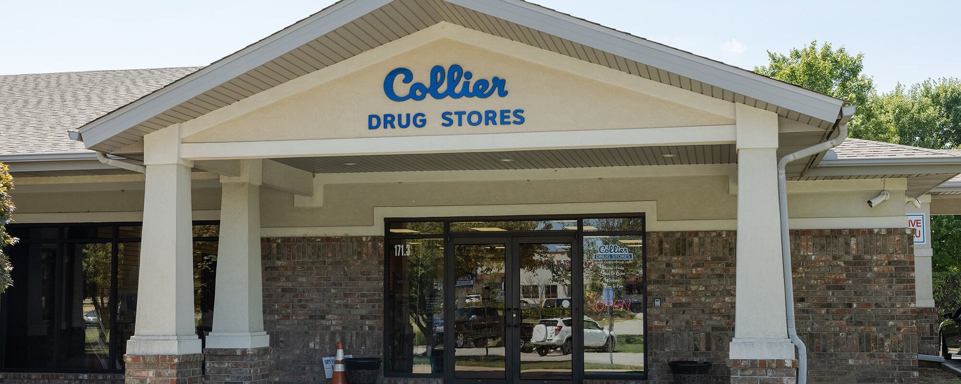 The front of a collier drug store with a blue sign above the entrance.