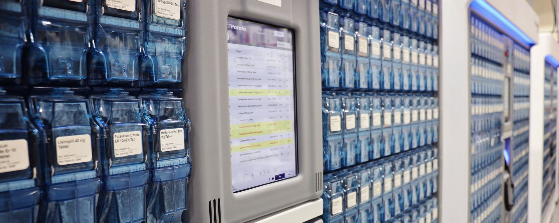 A computer monitor is sitting on a wall in a warehouse.