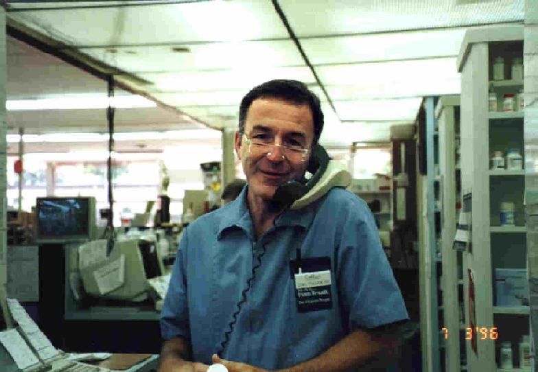 A man in a blue shirt is talking on a phone