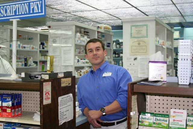 Two men are looking at a book together in a black and white photo