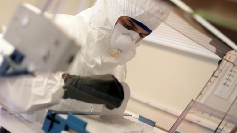 A computer monitor is sitting on a wall in a warehouse.