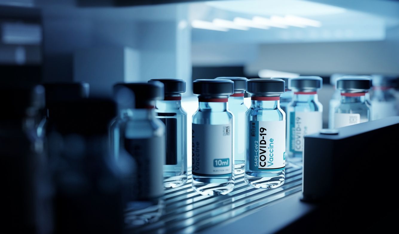 A conveyor belt filled with bottles of covid-19 vaccine in a laboratory.