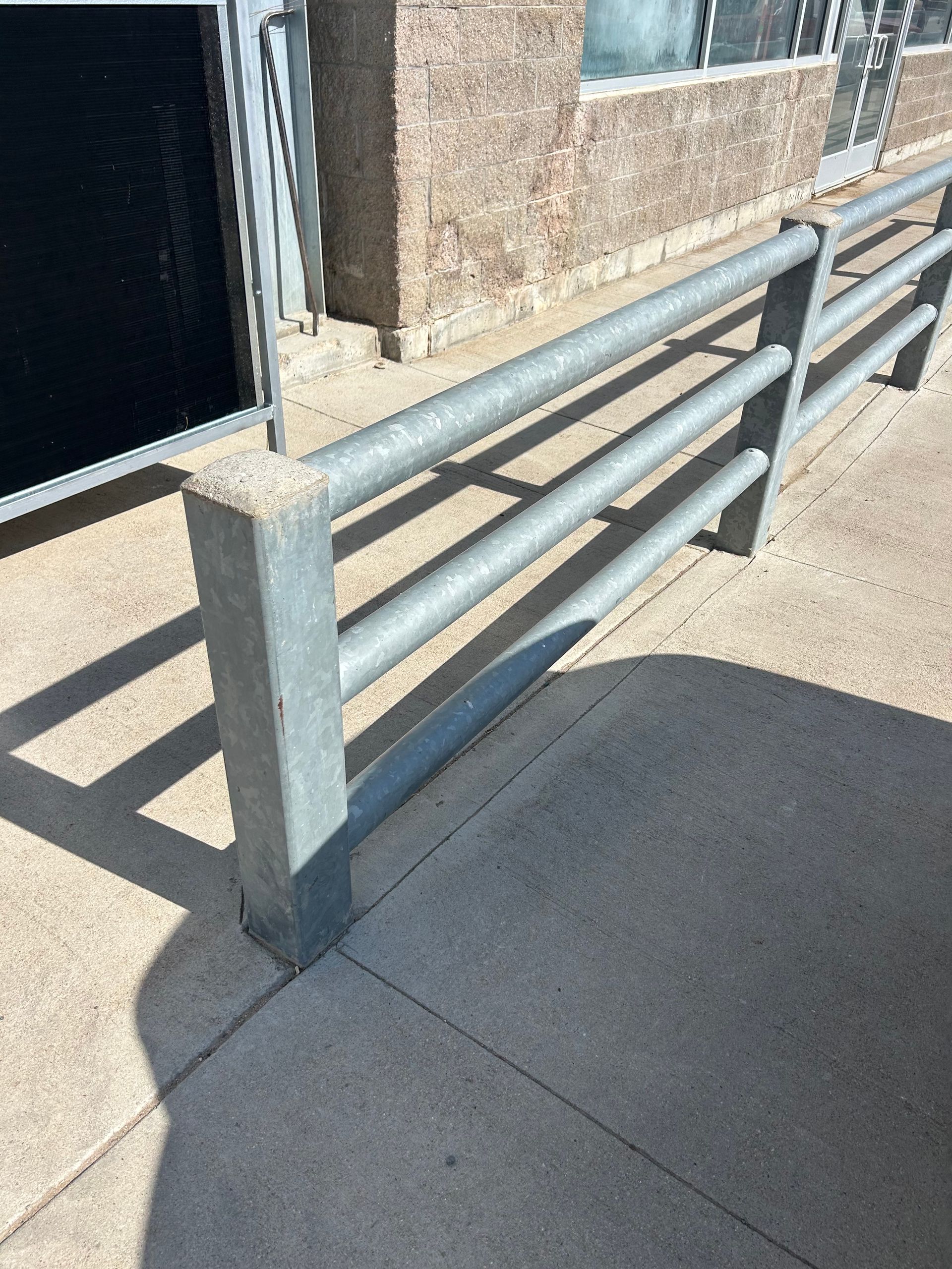 A metal fence is sitting on the sidewalk in front of a building.