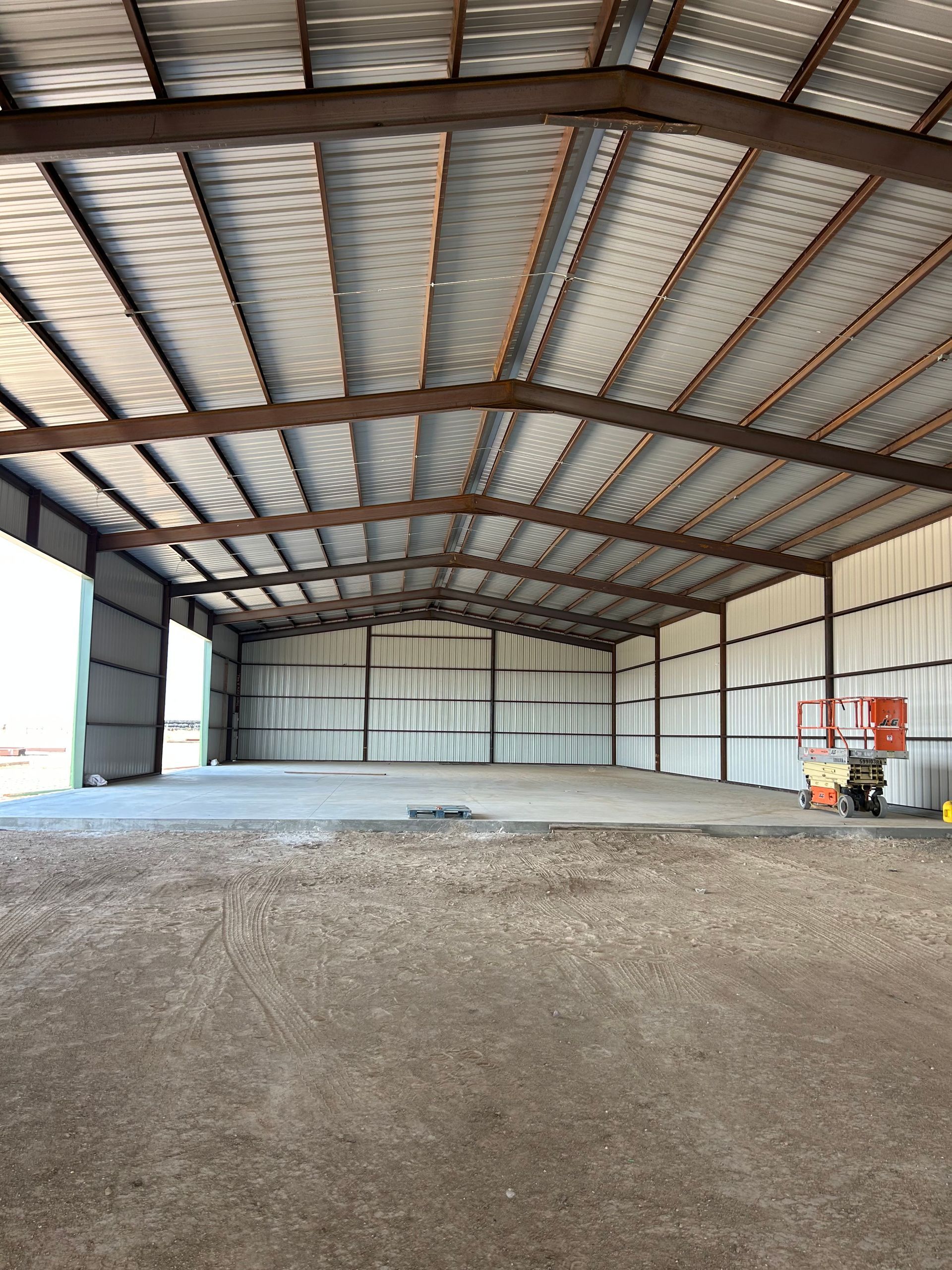 A large empty warehouse with a metal roof