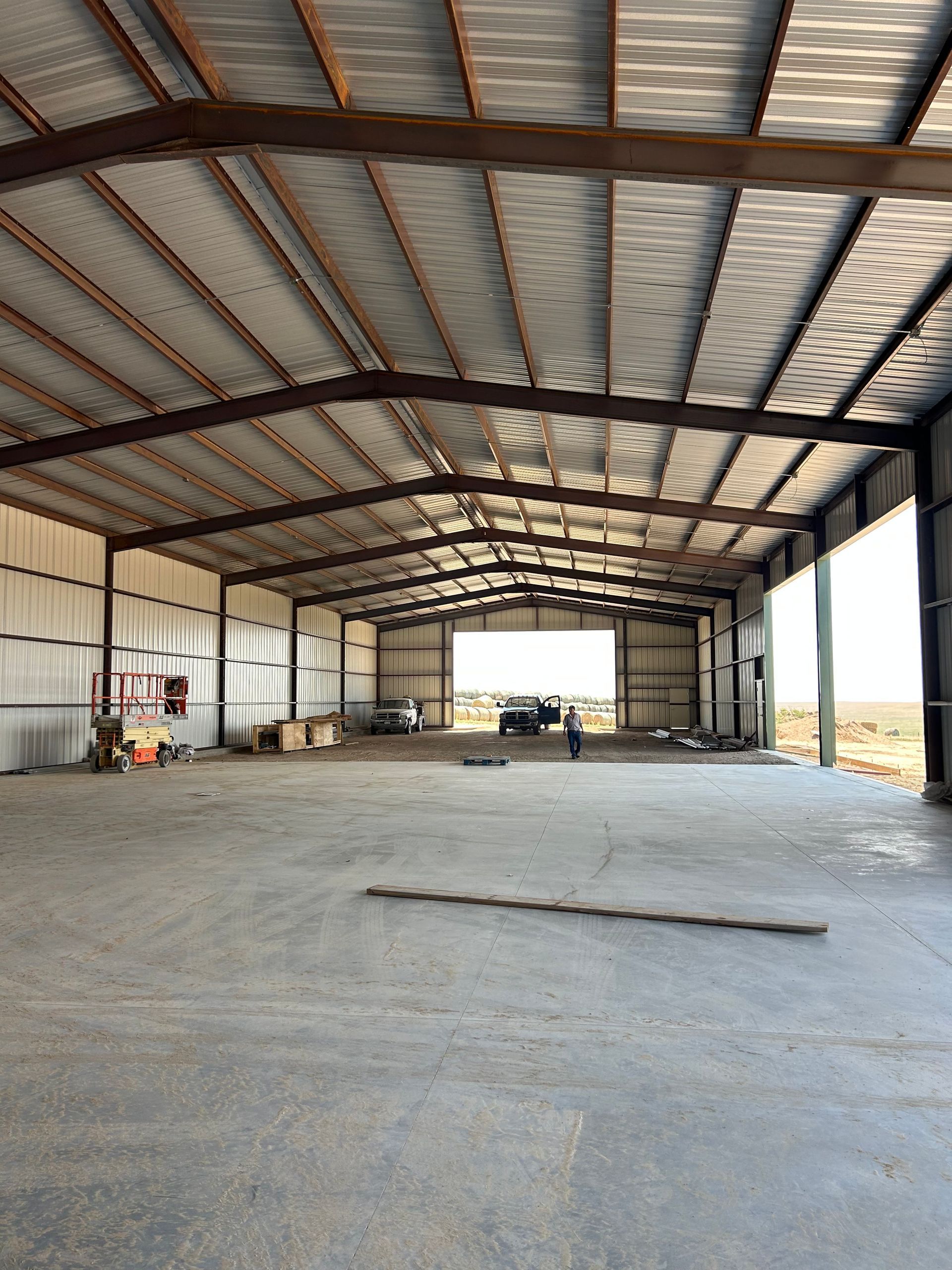 A large warehouse with a concrete floor and a metal roof.
