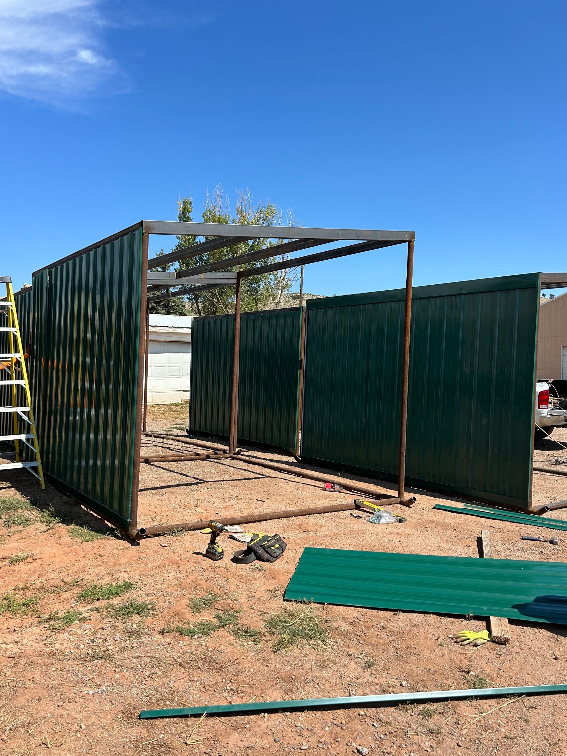 A shed is being built in the middle of a dirt field.