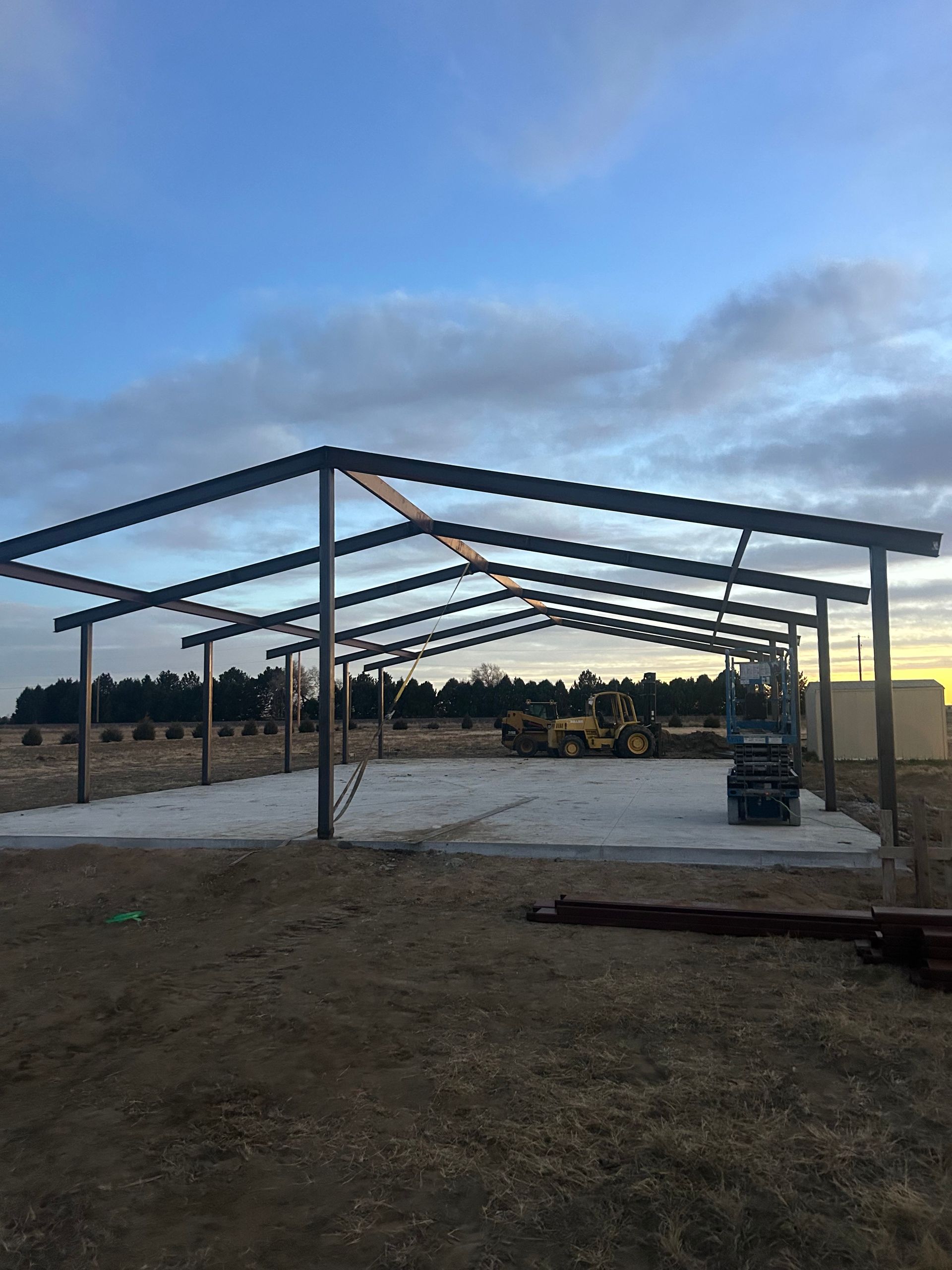 A large metal structure is being built in a field.