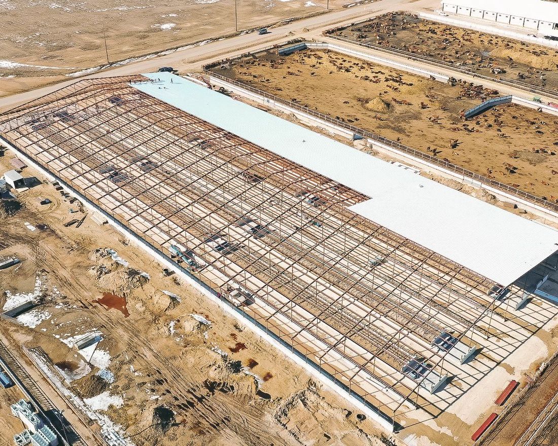 An aerial view of a large building under construction in the middle of a desert.