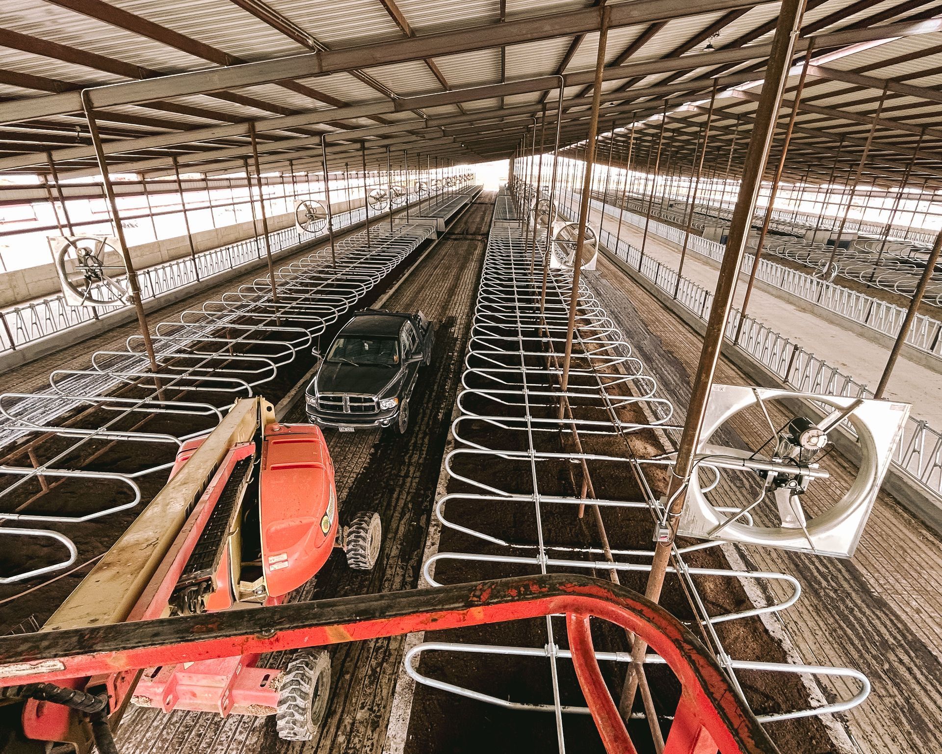 A truck is parked in a barn with a crane.