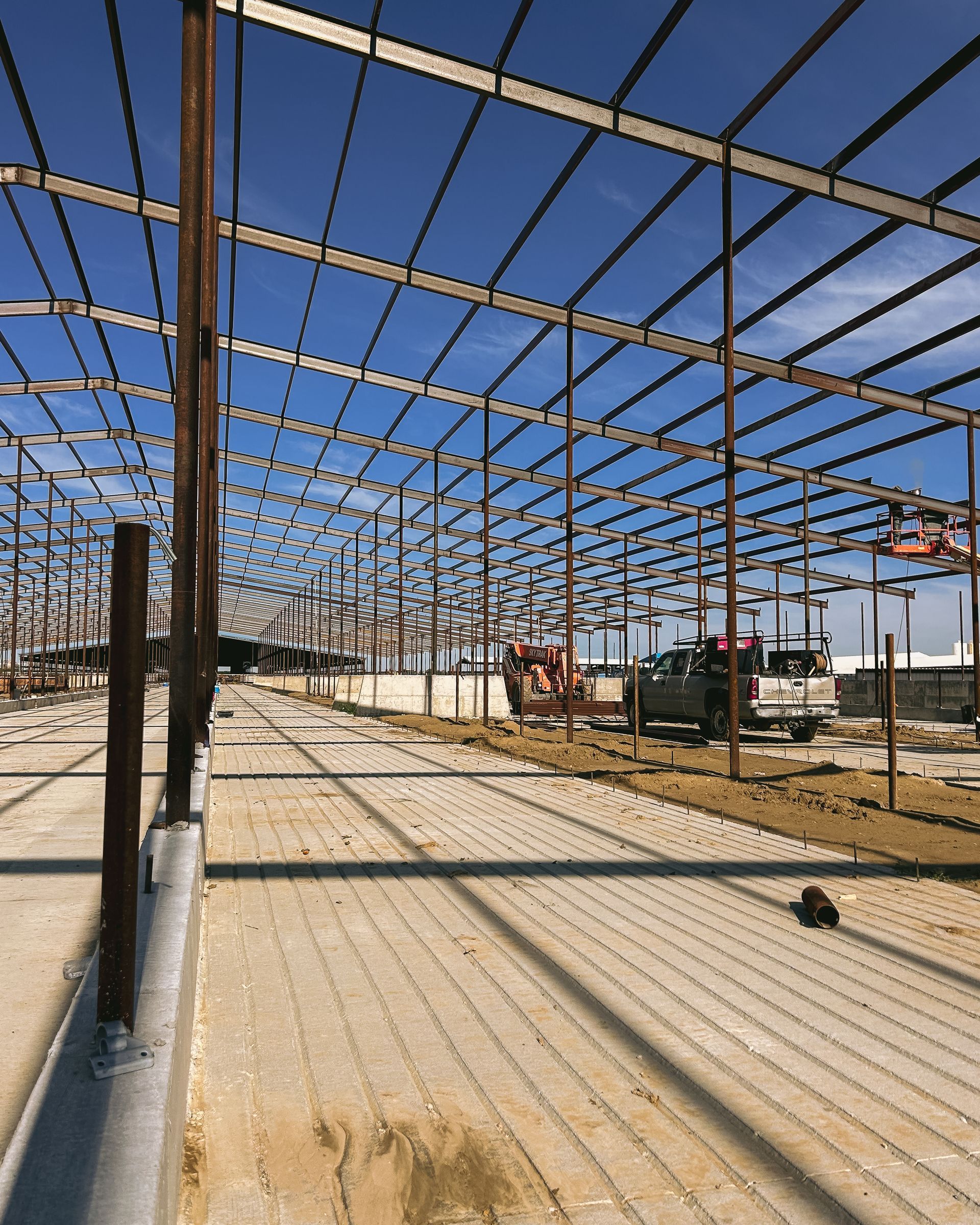 A large metal structure under construction with a blue sky in the background