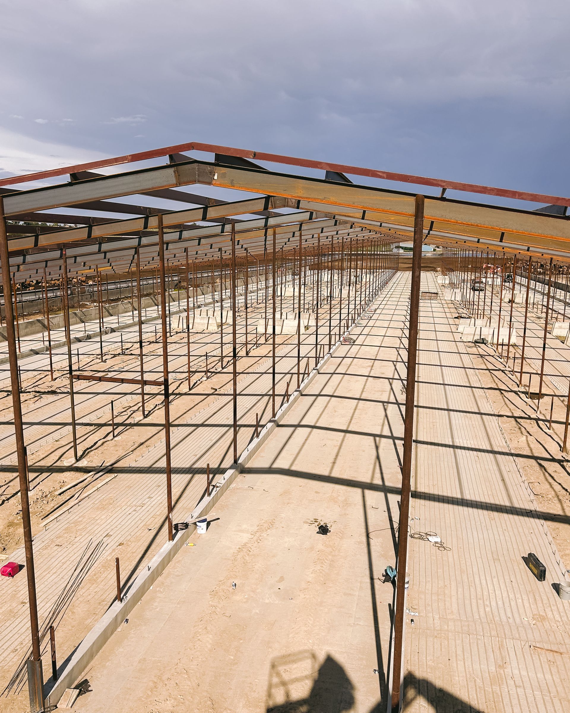 A large metal structure is being built in the middle of a dirt field.