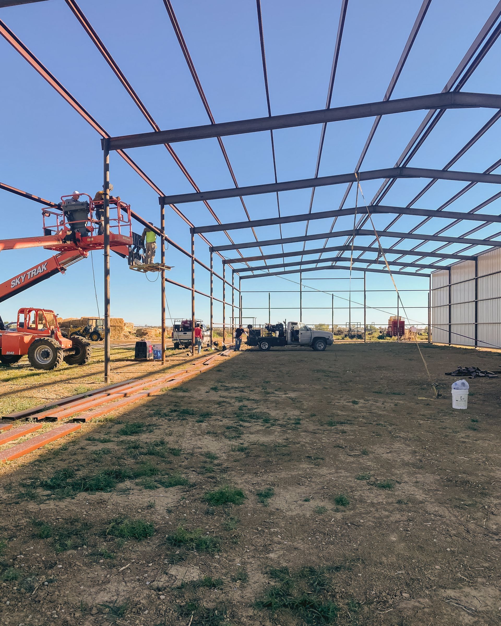 A large metal structure is being built in a field.