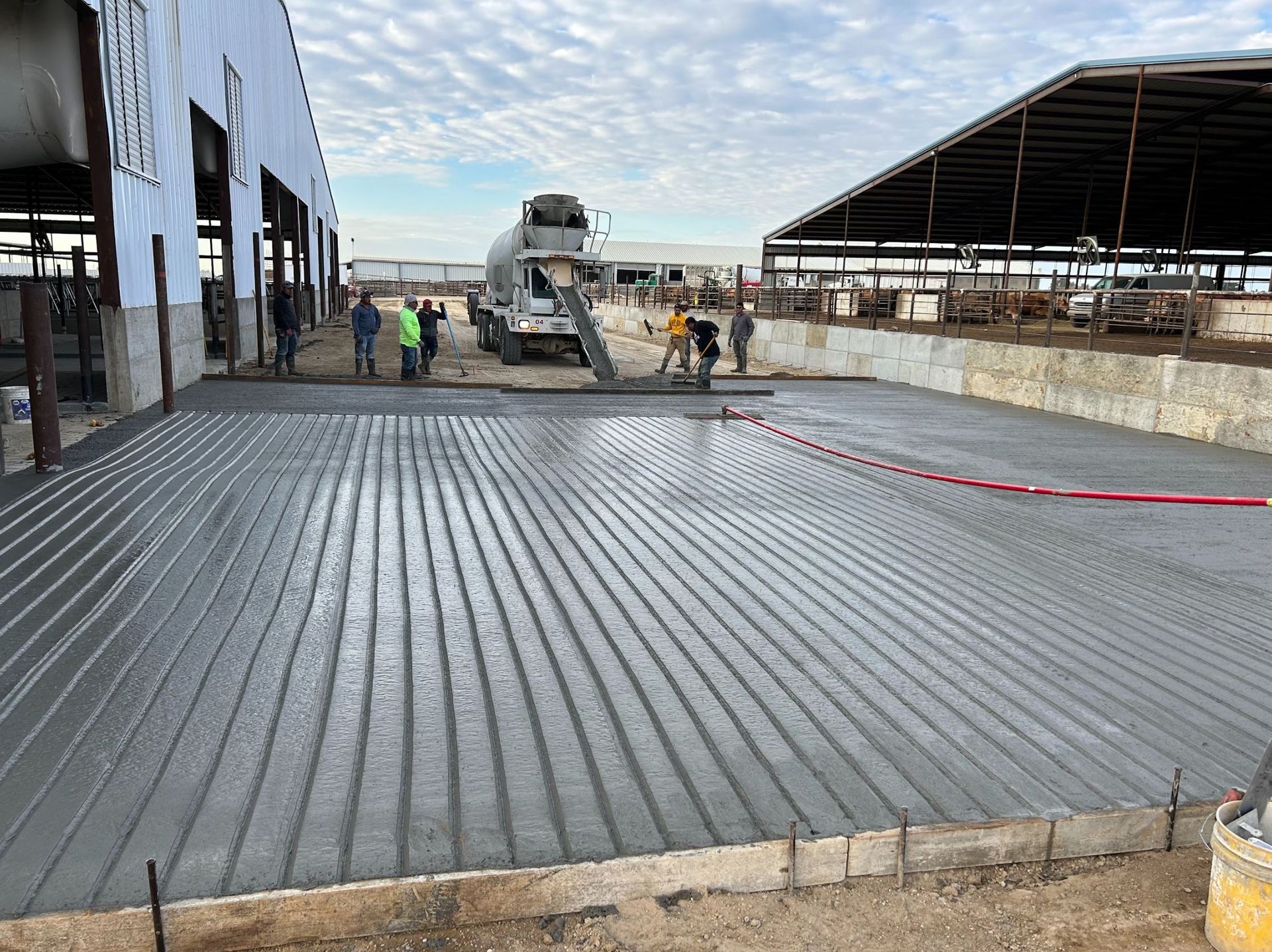 A concrete floor is being poured in front of a building.