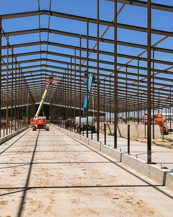 A large metal structure is being built on a sunny day