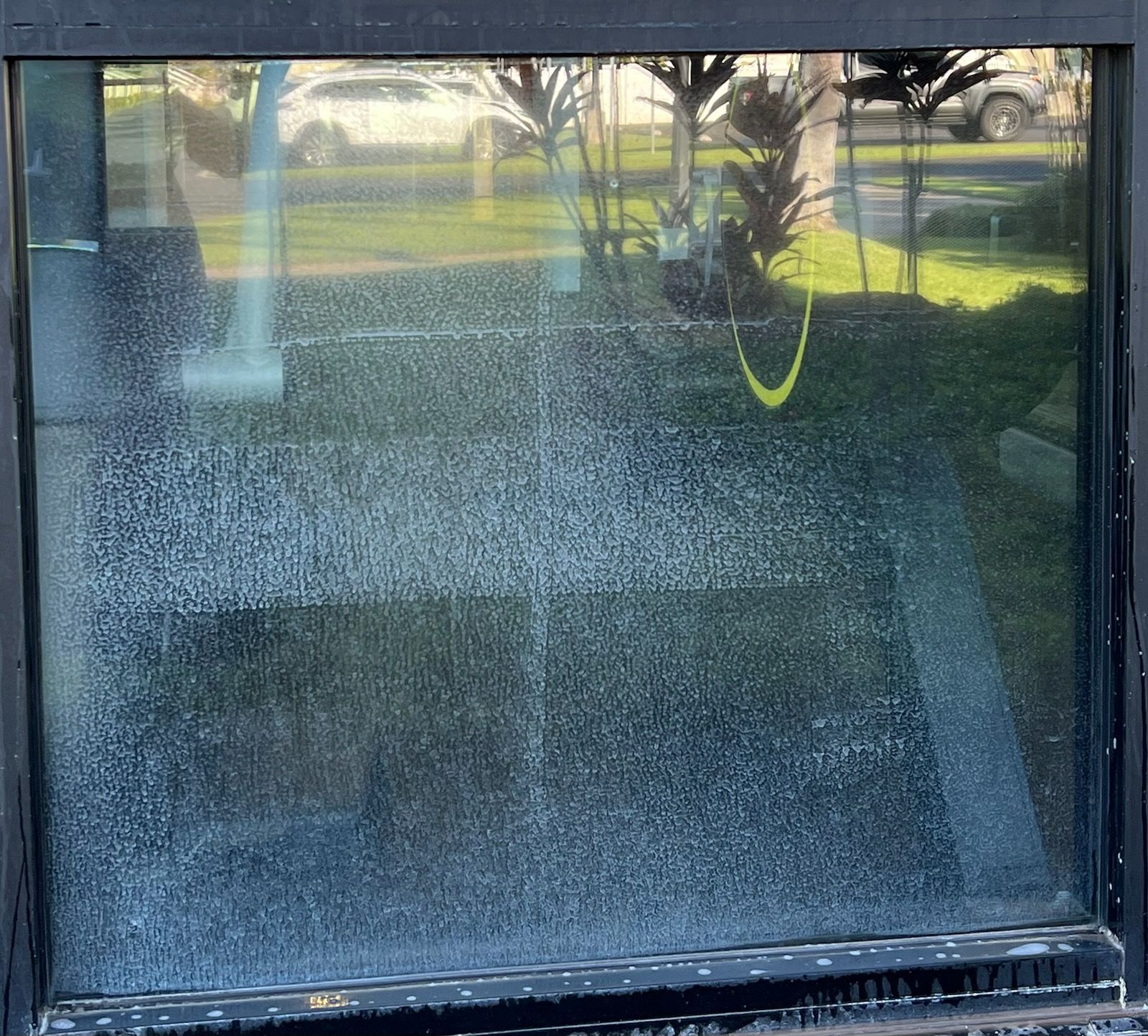 A close up of a glass door with a lot of dust on it.