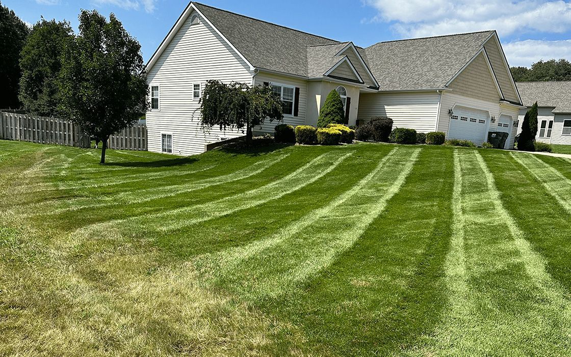 A large white house with a lush green lawn in front of it.